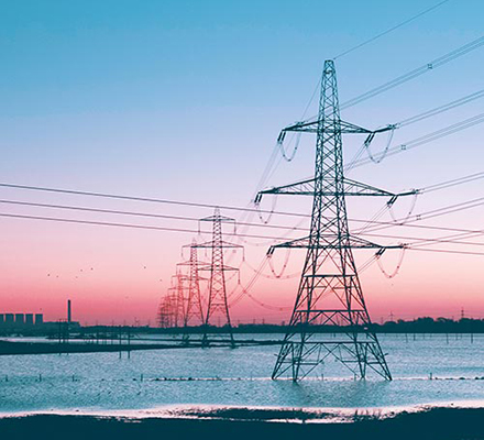 Row of transmission lines and a pink sky.