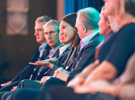 Group of Worley's Group Executive sitting in a row on stage.